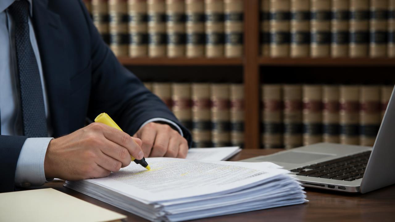Attorney researching authorities with law reporters and briefs in a law library
